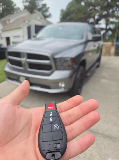Programmed key fob for a gray Ram 1500 pickup truck in a driveway