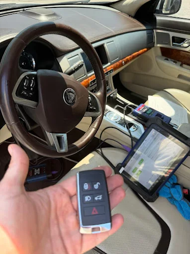 Jaguar smart key being programmed with a diagnostic tablet inside the car